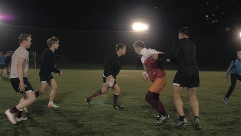 Workout of rugby professional team outdoor at night, football training