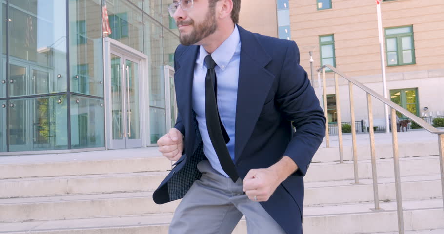 Handsome millennial businessman celebrating and silly goofy dancing directly into the camera celebrating his achievement and success in 4k. Royalty-Free Stock Footage #30420625