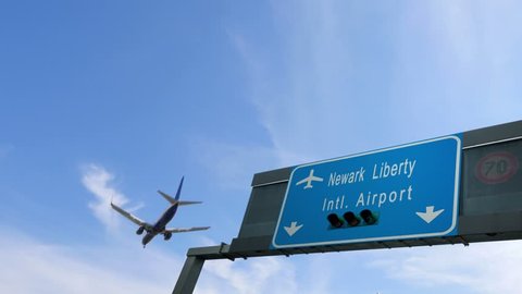 airplane flying over newark airport signboard