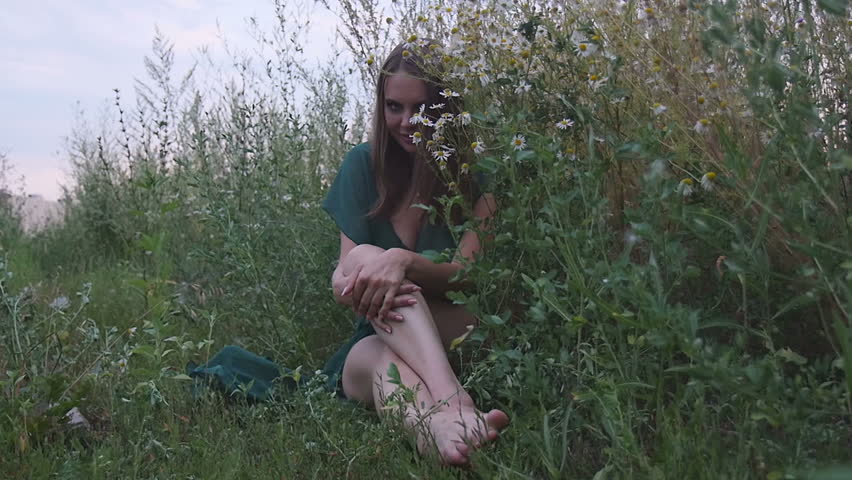 Sexy Girl Sitting in the Field With Flowers