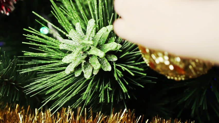child decorates a Christmas tree closeup