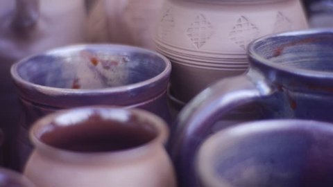 Beautiful Pottery. on a Table Are Beautiful Mugs, Cups and Jugs. All of Them Are Made by One Master. on a Front Side of Mugs, Cups and Jugs Are Seen a Beautiful Patterns. Some Cups Are Covered With
