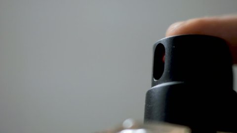 Macro detail of perfume bottle hand spraying