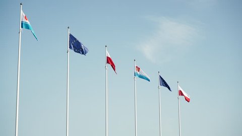 Flags against sky in the wind. Flag of Poland, the flag of European Union and the flag of polish city Gdynia 4K ProRes HQ codec