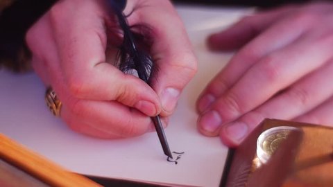 Teacher of Calligraphy Demonstrates a Process of Writing of Beautiful Letters With Black Ink and an Bird's Feather. a Beautiful Golden Ring With Carved Patterns is on a Man's Finger. Black Letters,