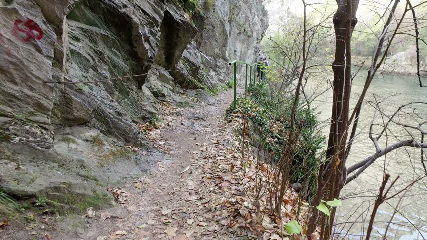 Hiker hike on narrow path at famous Treska canyon on Matka lake with the deepest underwater caves in the world