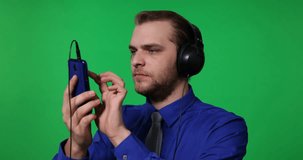 Young Business Man Browsing Mobile Phone with Headphones Green Screen Background