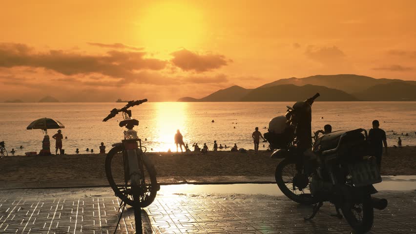 Several motorcycles stand in the parking lot on the embankment of Nha Trang. Vietnam. Evening time and sunset.