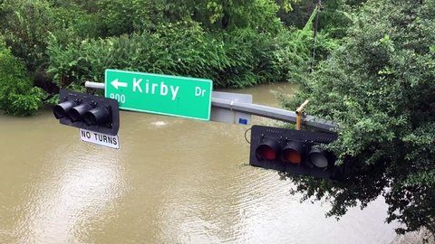 A street sign hanging over a flooded street after Hurricane Harvey came through town.