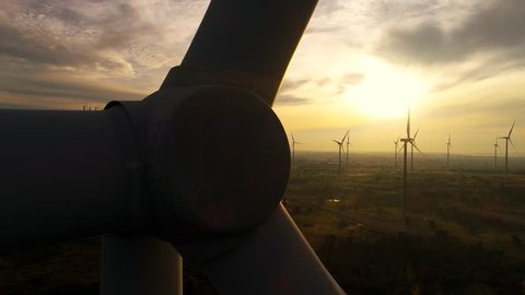 4k drone footage of wind farm turbines at sunrise with clouds