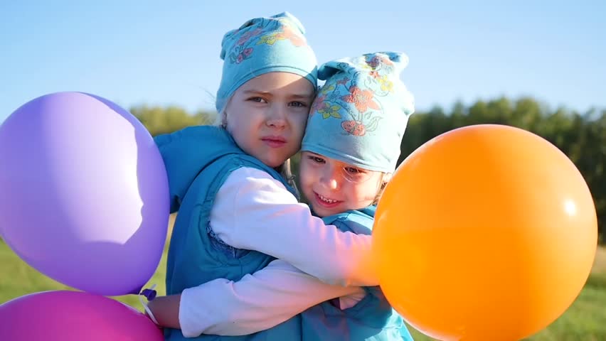Two twin sisters hugging and kissing. Children hold balloons | Shutterstock HD Video #30471907