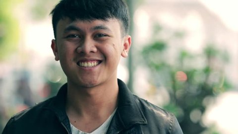 Portrait of handsome south east asian young man smiling on camera with three kind of tones (cyan - orange, contrast, and raw)