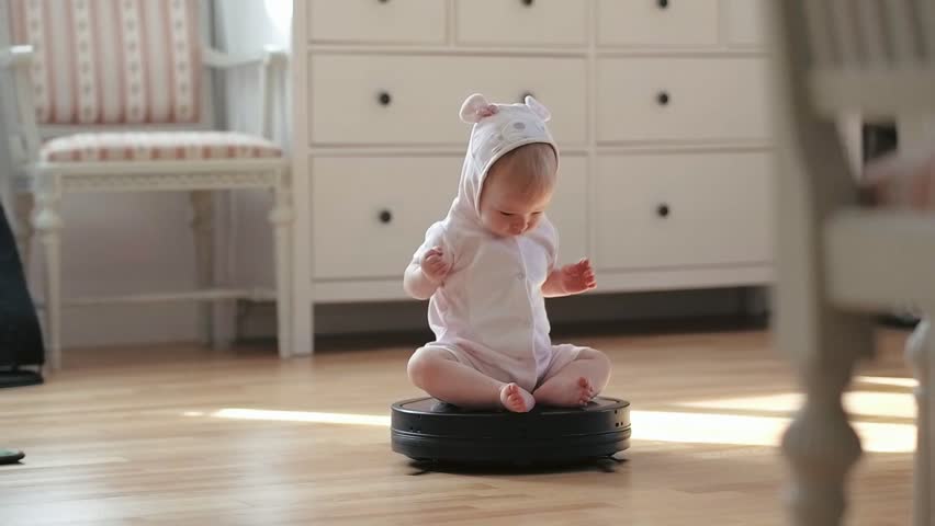 Little baby girl rolling on moving robot vacuum cleaner while cleaning home Royalty-Free Stock Footage #30475018