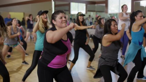 Medium panning shot of students dancing in exercise class / Orem, Utah, United States