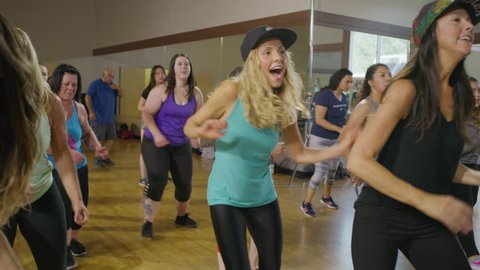 Medium slow motion panning shot of women dancing in exercise class / Orem, Utah, United States