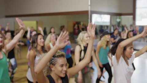 Medium panning shot of people dancing in exercise class / Orem, Utah, United States