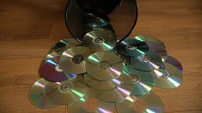 Several useless digital discs falling out of the dustbin. Conceptual slow motion footage for technology development.