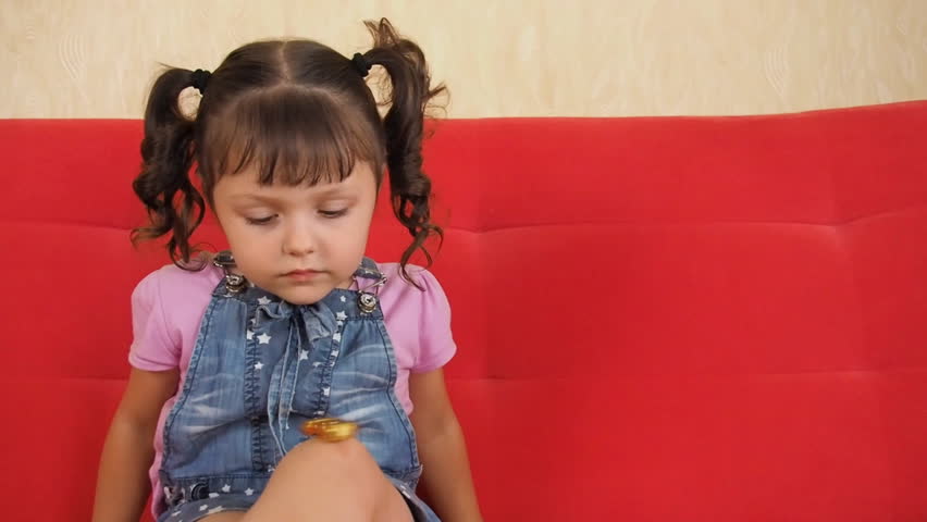 A little girl is playing with a spinner. The child turns the spinner on the leg.
