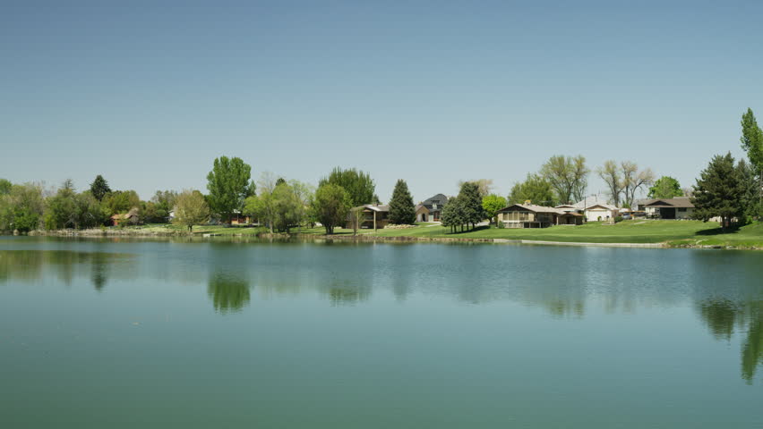 Wide panning shot of distant houses at lakes / Salem, Utah, United States