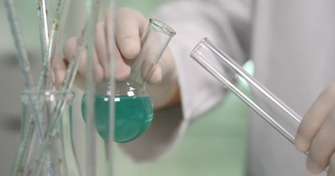 Scientist Adding Liquid to Test Tubes with Glass Bottles in Laboratory Close-Up