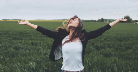 Portrait of Business Woman Standing on the Wind with Hands Up. SLOW MOTION 4K DCi. Businesswoman enjoying the wind, feeling free. Stormy weather, autumn, winter, spring.