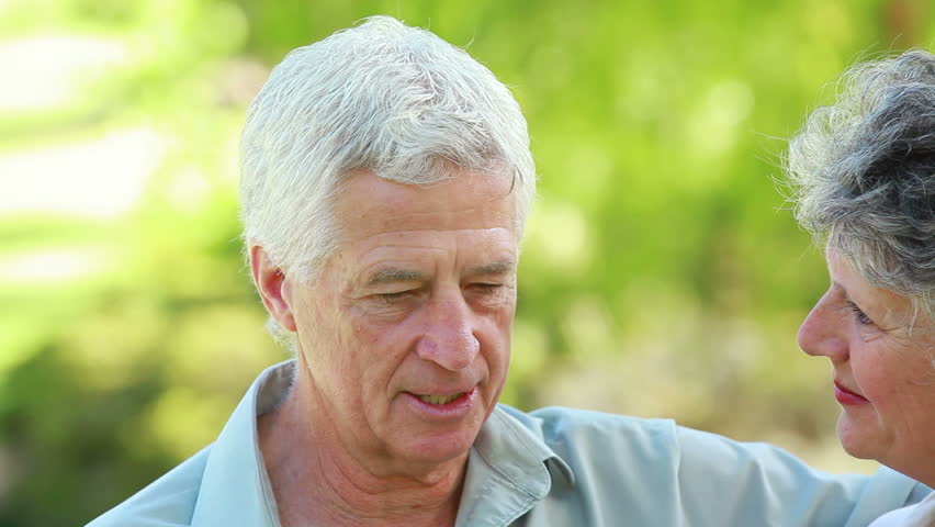 Smiling mature woman listening to her husband in the countryside