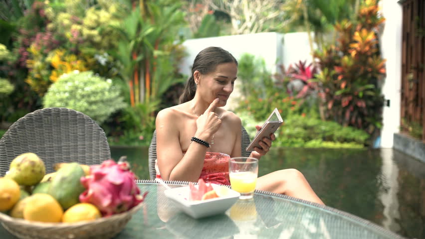 Attractive woman laughing while watching something funny on smartphone, steadycam shot
