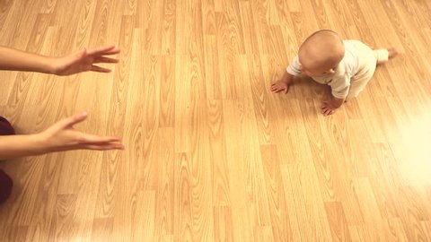 Baby crawling on the floor to his mother arms