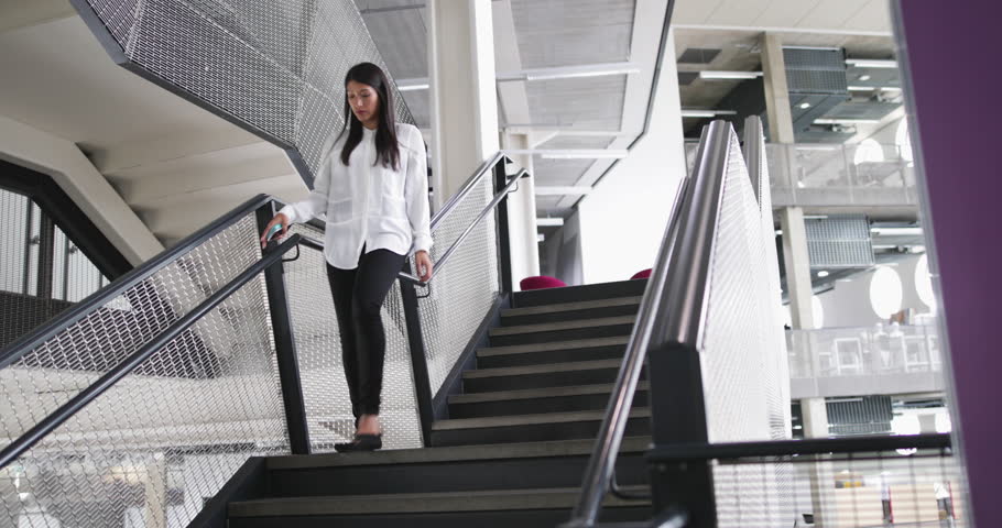 Businessman and businesswoman walking down stairs in an office | Shutterstock HD Video #30500017