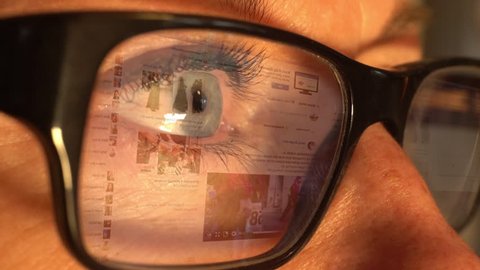 STOCKHOLM - SEPTEMBER 7, 2017: A woman using the social media channel Facebook with an animated screen reflection displayed in her glasses.