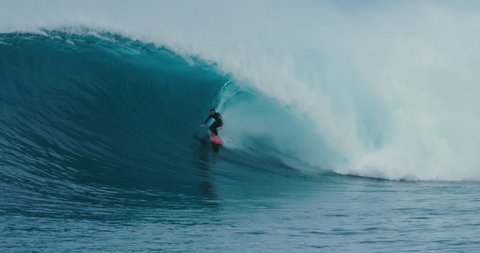 Surfer rides giant blue ocean wave. Shot on RED in 4k. Big wave surfing. Slow motion