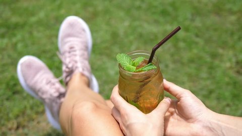 Woman Relaxing Outdoors With Fresh Mint Iced Tea In Summer. Closeup. 4K. 