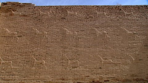HILLAH, IRAQ - CIRCA 2002: Pan-left on reliefs of gazelles and fantastical animals carved on the walls of ancient Babylon. Since 2003 Gulf War occupying forces caused irreparable damage to the site.
