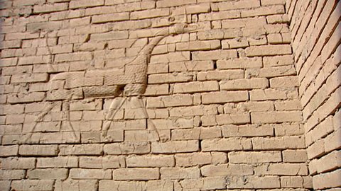 HILLAH, IRAQ - CIRCA 2002: Zoom-in from a bas relief of a fantastical animal to a brick stamped with cuneiform writing. Since the Gulf War occupying forces have caused irreparable damage to the site.