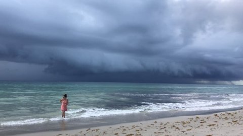 Hollywood, Florida - July 12,2017: Storm clouds approach  beach as people wait until the last moments to evacuate the beach before the rain begins.