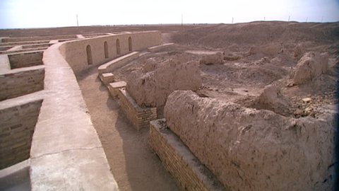 TELL EL-MUQAYYAR, IRAQ - CIRCA 2002: Archaeological site of Ur. pan-right from the so-called House of Abraham to mud brick walls and niche facade architecture. The Ur Ziggurat in the distance.