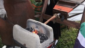 4K video footage of blacksmith with hot steal and hammer, close up processing