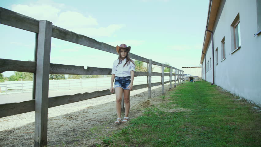 Smart little girl walks at the stable. 4K