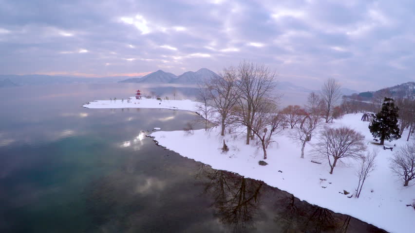 Aerial of Japanese Temple and Boat on Mirror Lake at Sunrise with Purple and Pink Hues in 4K