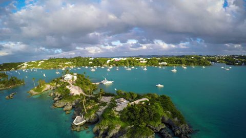 Aerial Views of Bermuda Boats and Sailboats during Sunset with Golden Light and Turquoise Waters and Green Lands with Ominous Clouds in 4K