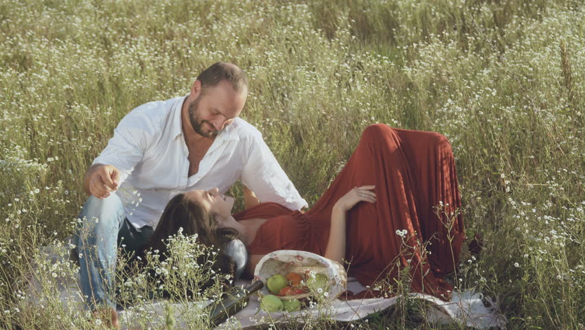 In love couple relax at the plaid on the meadow