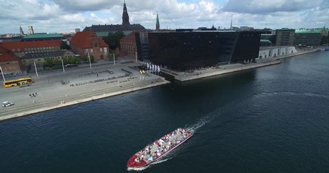 COPENHAGEN, DENMARK - AUGUST 22, 2017: Copenhagen Old Town and Cityscape with Royal Library and Christian IV's Brewhouse. Boat with tourists