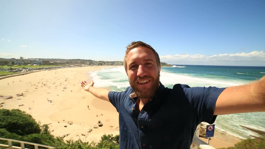 Young man takes a selfie portrait at Bondi beach, Australia
Young tourist taking a selfie at Sydney's most famous beach  Royalty-Free Stock Footage #30544093