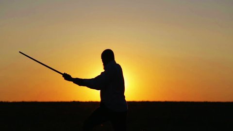 Portrait of a man with a sword at sunset, the path of a warrior. Samurai yakuza with a sword at sunset of the day. Sport, hobbies, interests.