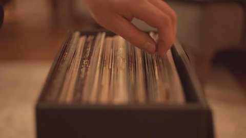 Hand browses vinyl record collection