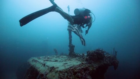 Underwater scuba diver holding up American Flag on the USS Spiegel Grove wreck, in the Florida Keys