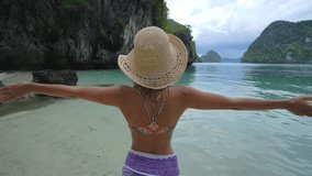 One young woman on tropical beach making a heart shape finger frame on idyllic landscape. People travel love environment concept