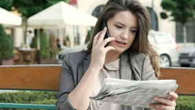 Attractive businesswoman looking on newspaper while speaking with someone on cellphone, steadycam shot
 - Powered by Shutterstock - Get 15% off with code: PIKWIZARD15