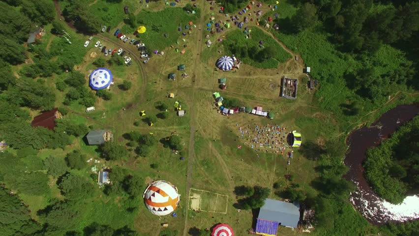 Aerial view flying from drone over camping in green landscape near the river.