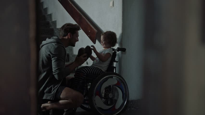 Young father taking care of his disabled child on a wheelchair | Shutterstock HD Video #30571168